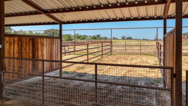 view of horse barn featuring an outdoor structure and a rural view