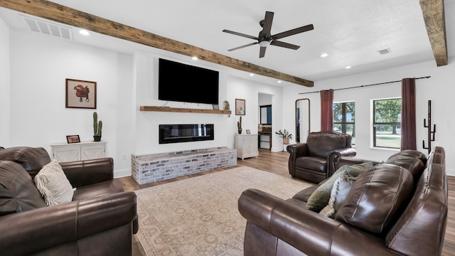 living room with ceiling fan, hardwood / wood-style flooring, and beam ceiling