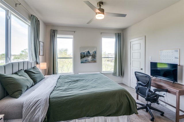 bedroom featuring light carpet, multiple windows, and ceiling fan