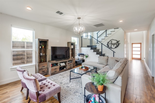 living room with a notable chandelier and light hardwood / wood-style flooring