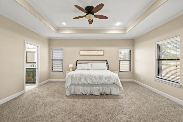 unfurnished bedroom featuring ceiling fan, light colored carpet, a raised ceiling, and ornamental molding