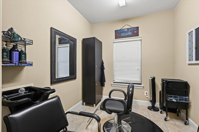 workout room featuring a textured ceiling and light tile patterned flooring