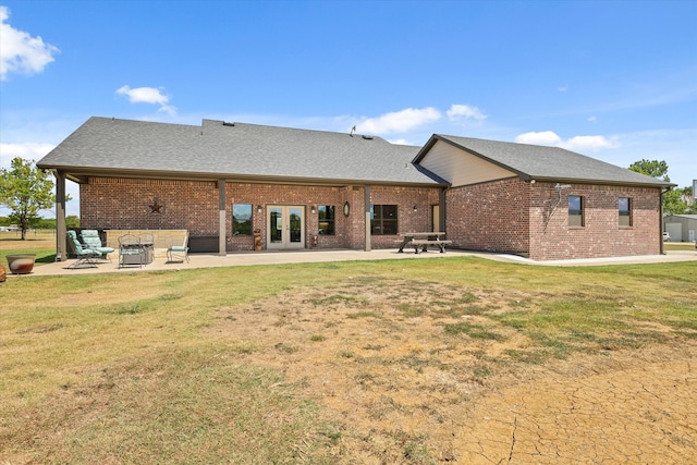 rear view of house with french doors, a yard, and a patio area