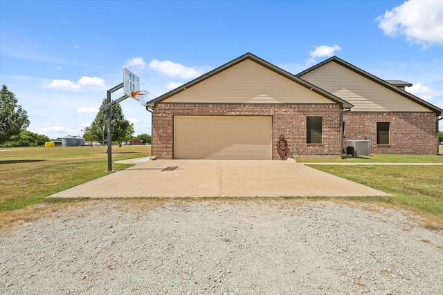 view of front of property with a garage, central AC unit, and a front lawn