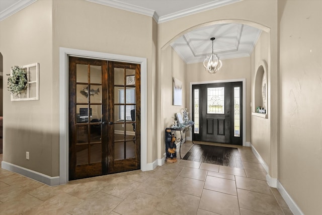 entrance foyer featuring an inviting chandelier, french doors, light hardwood / wood-style floors, coffered ceiling, and ornamental molding