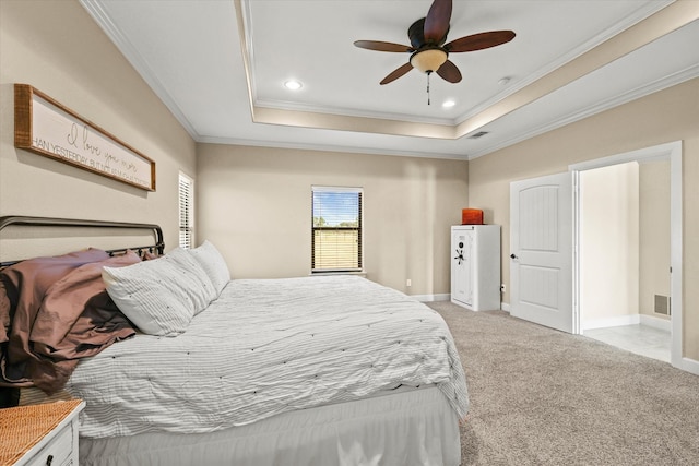 carpeted bedroom featuring ornamental molding, a tray ceiling, and ceiling fan