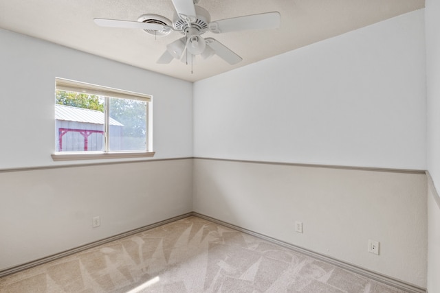 empty room with ceiling fan and light colored carpet