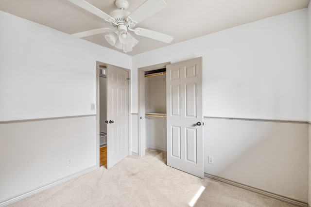 unfurnished bedroom featuring light colored carpet, ceiling fan, and a closet