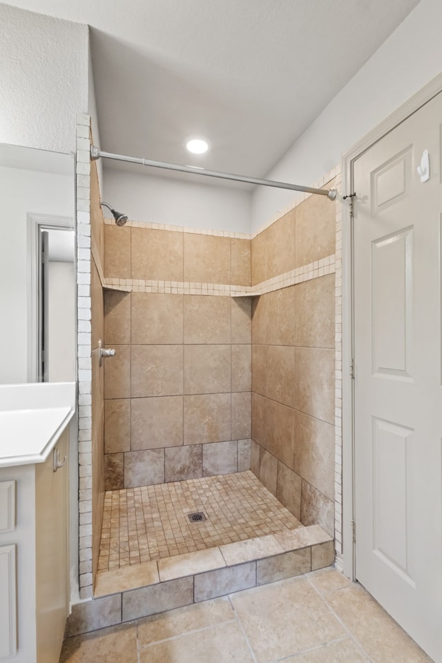 bathroom featuring tile patterned flooring and a tile shower