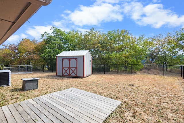 view of yard featuring a storage shed, a wooden deck, and central air condition unit