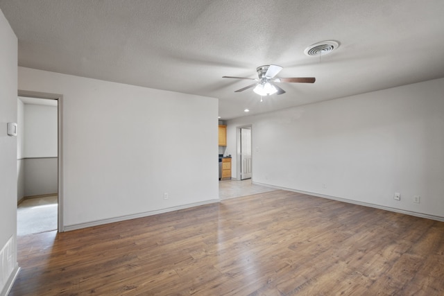 unfurnished room with a textured ceiling, hardwood / wood-style flooring, and ceiling fan