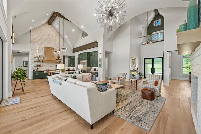 living room with light hardwood / wood-style floors, beamed ceiling, a notable chandelier, brick wall, and high vaulted ceiling