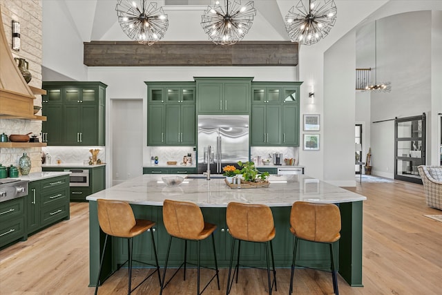 kitchen featuring light hardwood / wood-style flooring, high vaulted ceiling, appliances with stainless steel finishes, and tasteful backsplash