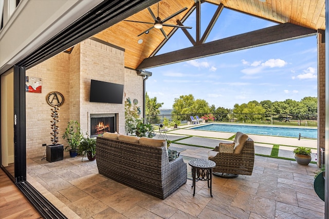 view of patio / terrace with an outdoor living space with a fireplace, a fenced in pool, and ceiling fan