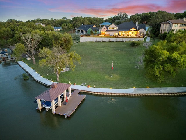 aerial view at dusk featuring a water view