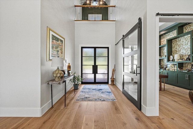 9 Meadowlake Dr, Heath, TX 75032 - foyer featuring a barn door, a towering ceiling, french doors, and light wood-style floors
