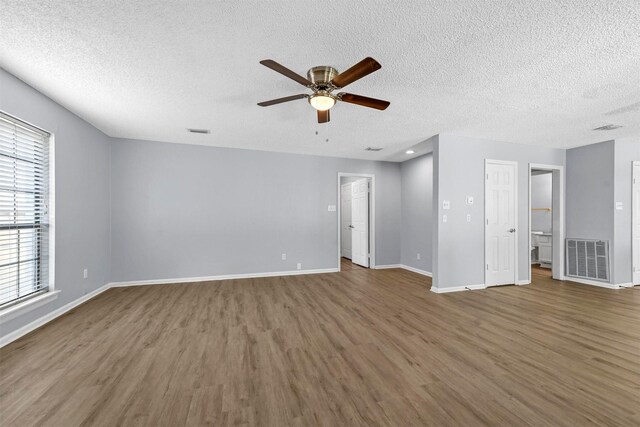 empty room with a textured ceiling, ceiling fan, and hardwood / wood-style floors