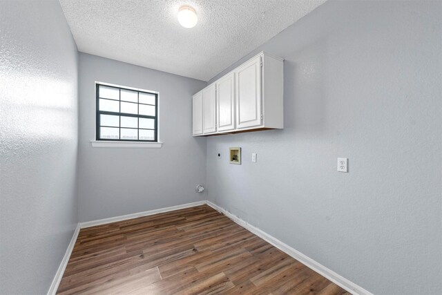 laundry area with dark hardwood / wood-style flooring, electric dryer hookup, washer hookup, cabinets, and a textured ceiling