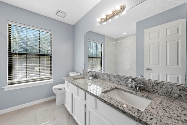 bathroom featuring a textured ceiling, vanity, tile patterned flooring, toilet, and a shower