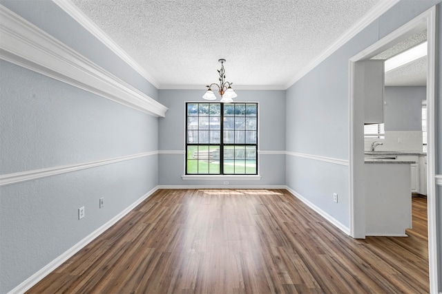 unfurnished dining area with a textured ceiling, ornamental molding, and wood-type flooring