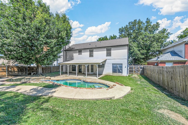 rear view of property with a lawn, a fenced in pool, and a patio