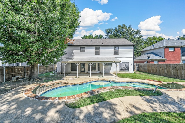 exterior space featuring a swimming pool with hot tub and a patio