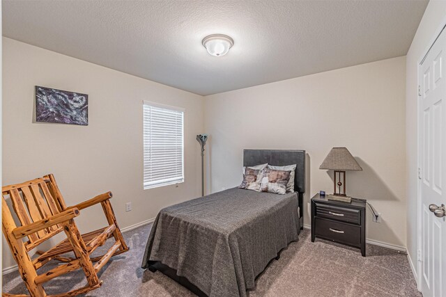 carpeted bedroom featuring a textured ceiling and a closet