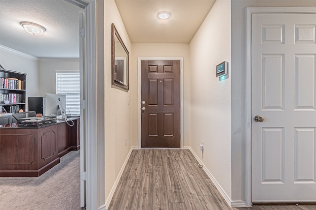 doorway to outside with a textured ceiling and light wood-type flooring