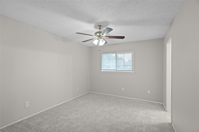 carpeted spare room with a textured ceiling and ceiling fan