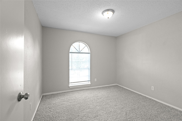 carpeted empty room with a textured ceiling