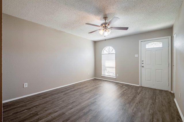 entryway with dark wood-type flooring, ceiling fan, a textured ceiling, and baseboards