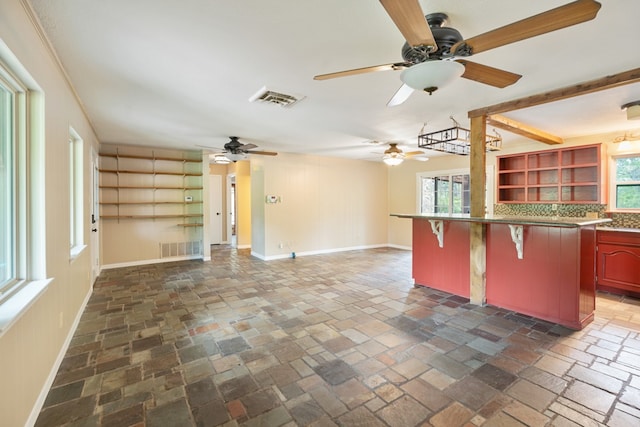 kitchen featuring tasteful backsplash, ceiling fan, and a breakfast bar area