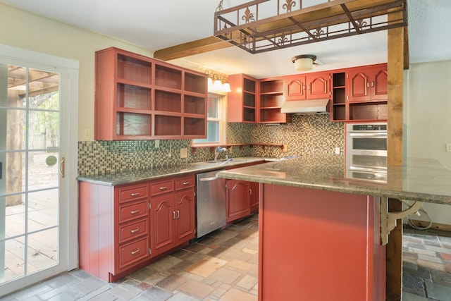 kitchen with kitchen peninsula, appliances with stainless steel finishes, tasteful backsplash, and a breakfast bar area