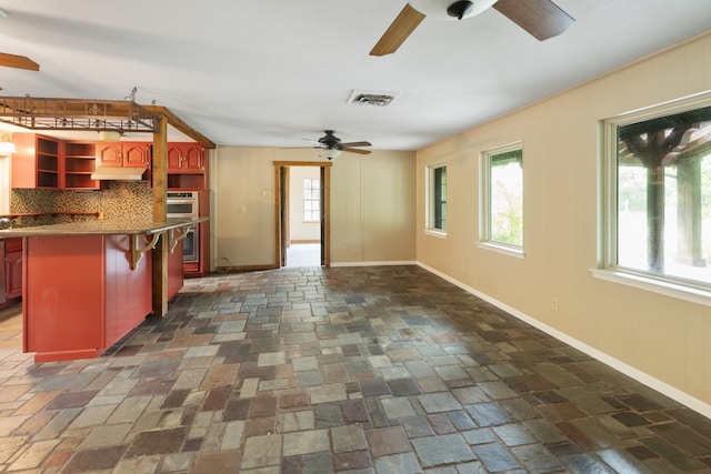 kitchen featuring a breakfast bar area, decorative backsplash, a kitchen island, and double oven