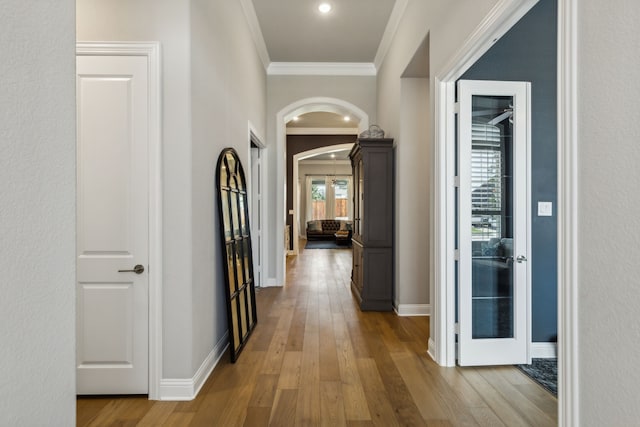 hall with ornamental molding and hardwood / wood-style floors