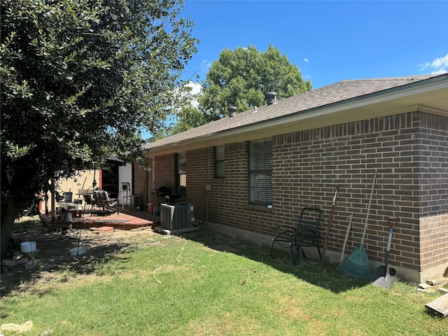 rear view of house with central AC, a lawn, and a deck