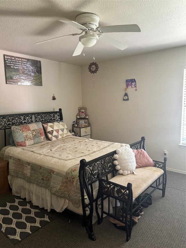 carpeted bedroom featuring ceiling fan and a textured ceiling