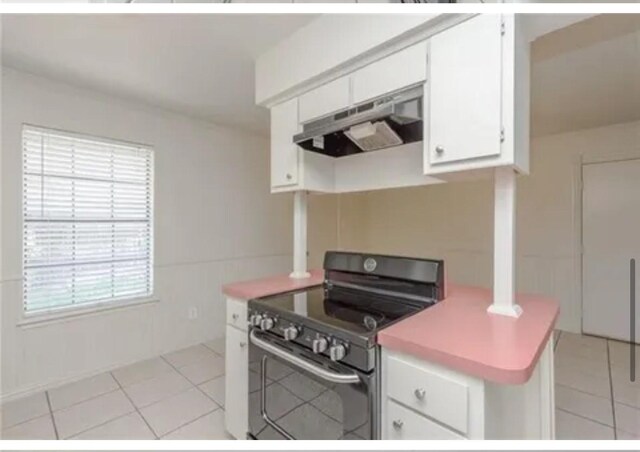 kitchen featuring white cabinets, stainless steel electric stove, extractor fan, and a healthy amount of sunlight