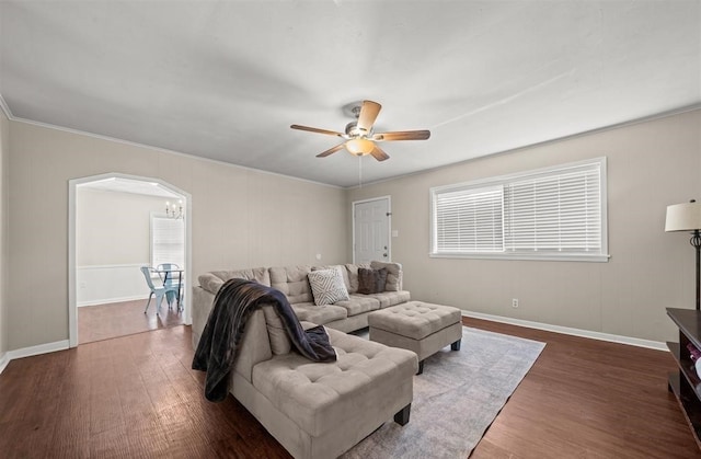 living room featuring ceiling fan, ornamental molding, and dark hardwood / wood-style flooring