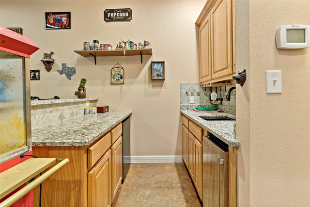 kitchen featuring tasteful backsplash, light tile patterned floors, light stone counters, sink, and stainless steel dishwasher