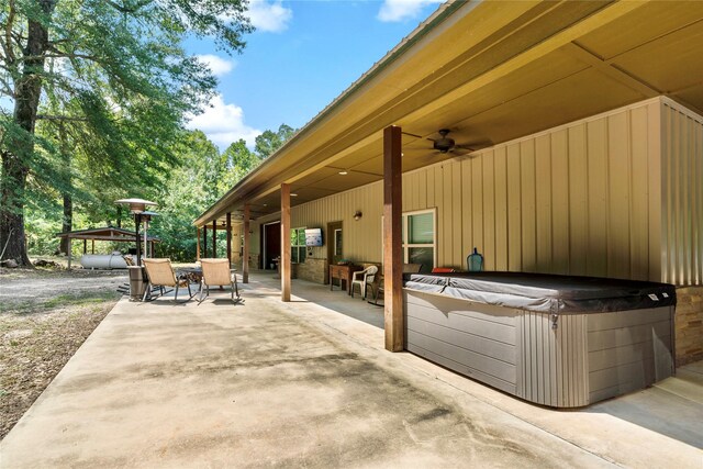 view of patio with ceiling fan and a hot tub