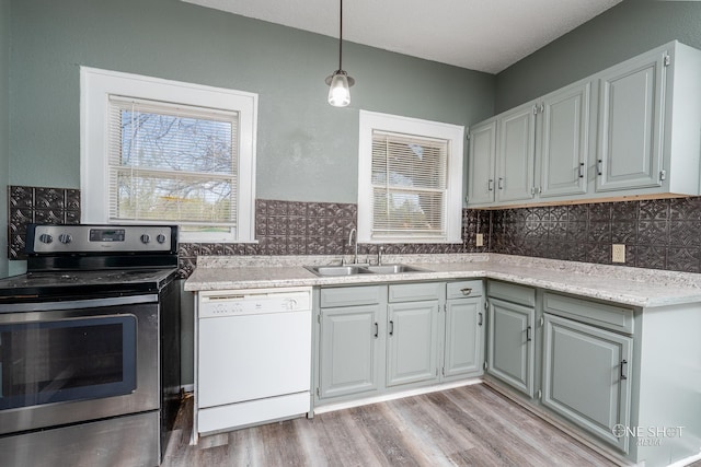 kitchen featuring light wood-type flooring, white dishwasher, electric stove, and sink