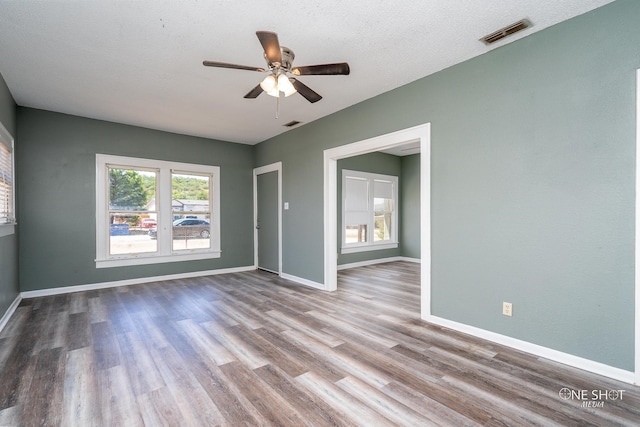 spare room featuring a textured ceiling, plenty of natural light, ceiling fan, and hardwood / wood-style floors