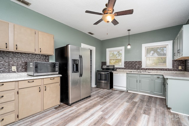 kitchen featuring stainless steel appliances, light wood-type flooring, ceiling fan, and tasteful backsplash