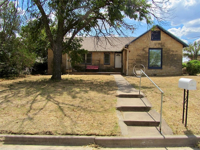 ranch-style house featuring stone siding and a front lawn