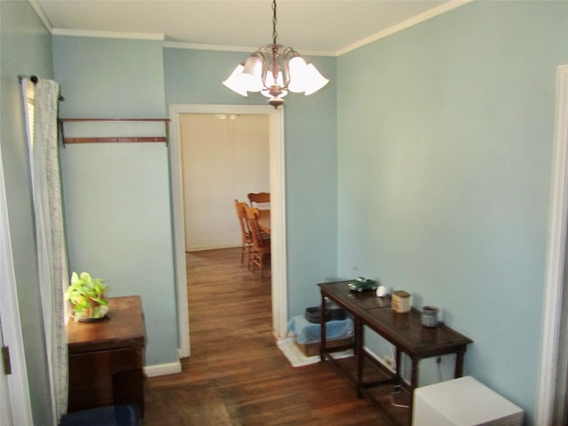 corridor featuring crown molding, dark hardwood / wood-style floors, and a notable chandelier