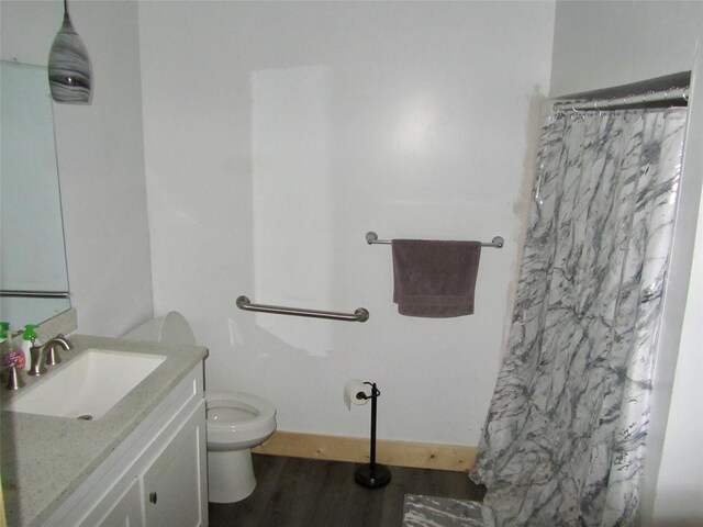 full bath featuring baseboards, toilet, a shower with shower curtain, wood finished floors, and vanity