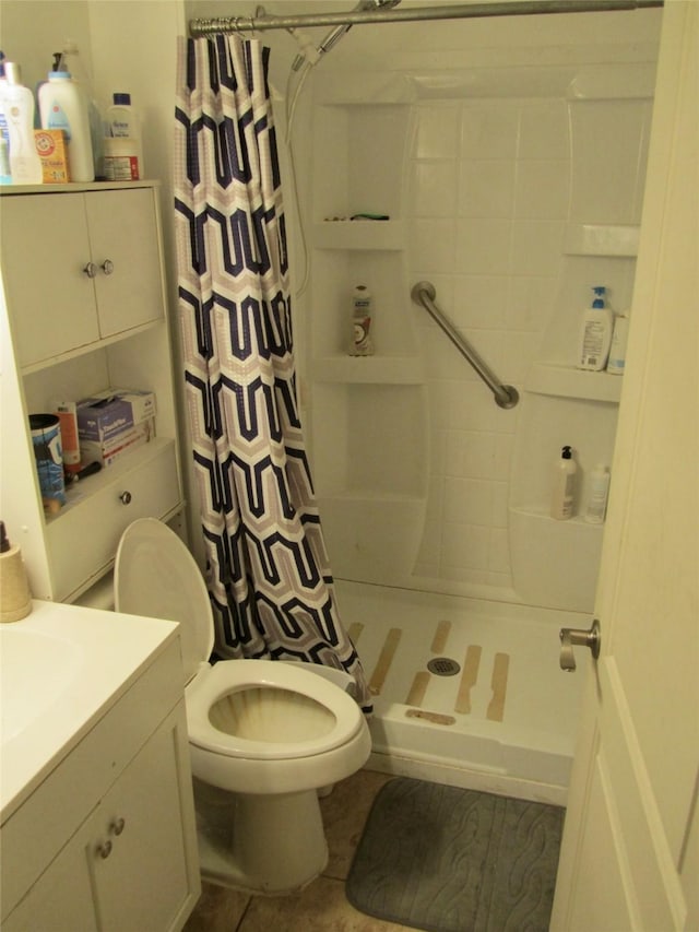 bathroom featuring vanity, a shower stall, toilet, and tile patterned flooring