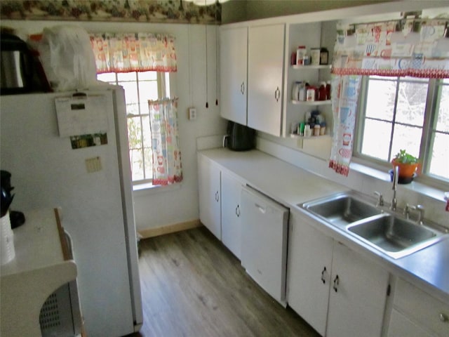 kitchen featuring white appliances, a sink, light countertops, white cabinets, and light wood-type flooring