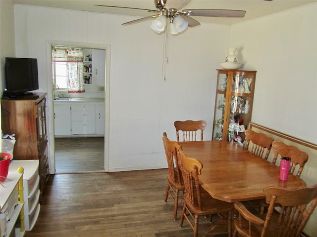 dining space featuring wood-type flooring, sink, and ceiling fan